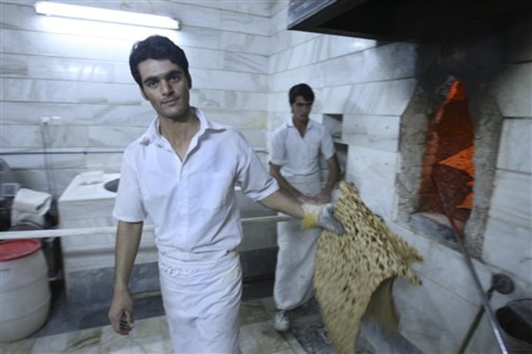 An Iranian baker doing work at his bakery in central Tehran, Iran, on Saturday. Iran's President Mahmoud Ahmadinejad announced the start of a plan to slash energy and food subsidies, part of government efforts to boost the nation's ailing economy. 